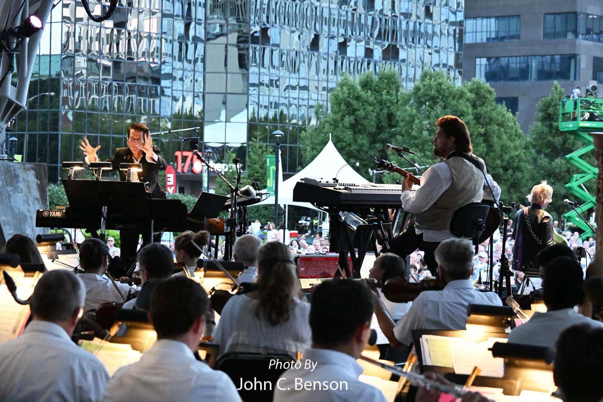 Tom Brooks conducting while a soloist plays at the front of the stage